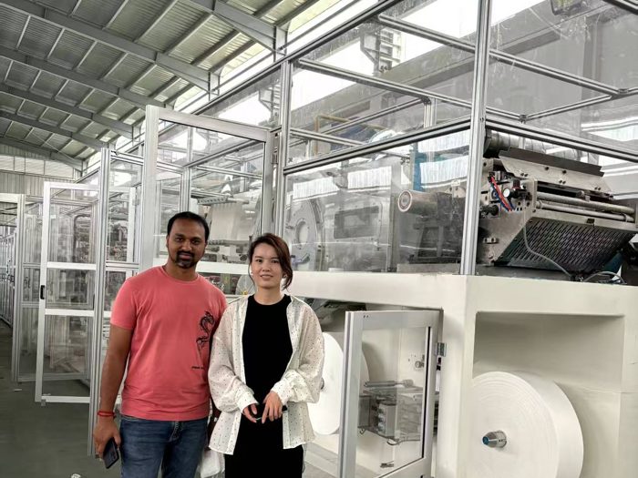 Two visitors standing beside production machinery