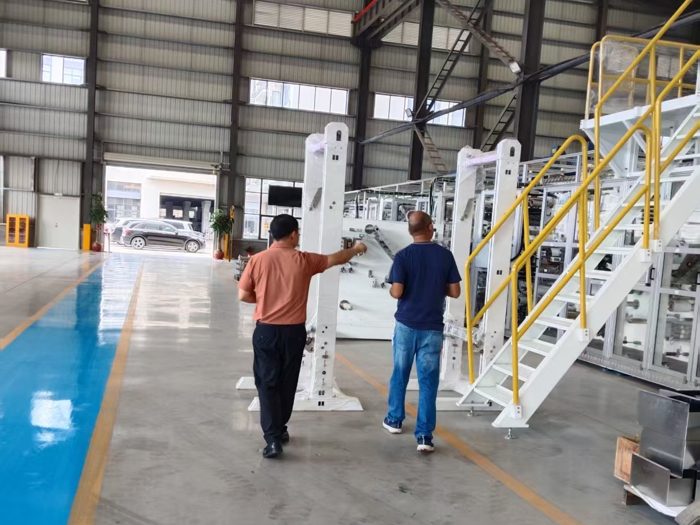 Two visitors walking beside production machinery on the factory floor