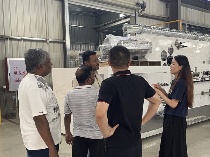 Visitors gathered beside production machinery in the workshop
