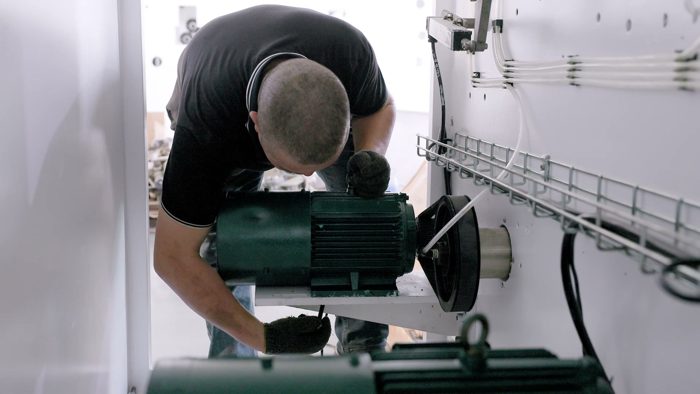 Technician checking a motor assembly on production machinery