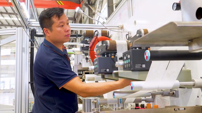 Technician checking a feed assembly on production machinery
