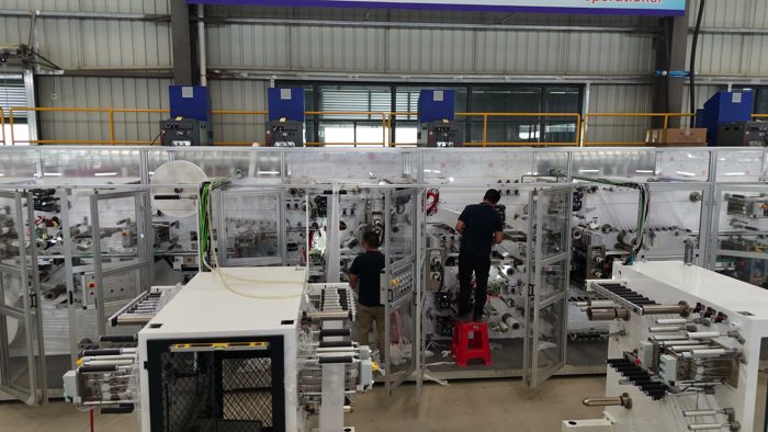 Wide view of production machinery with technicians at work
